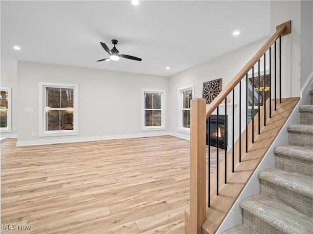 living room featuring a wealth of natural light, light hardwood / wood-style flooring, and ceiling fan