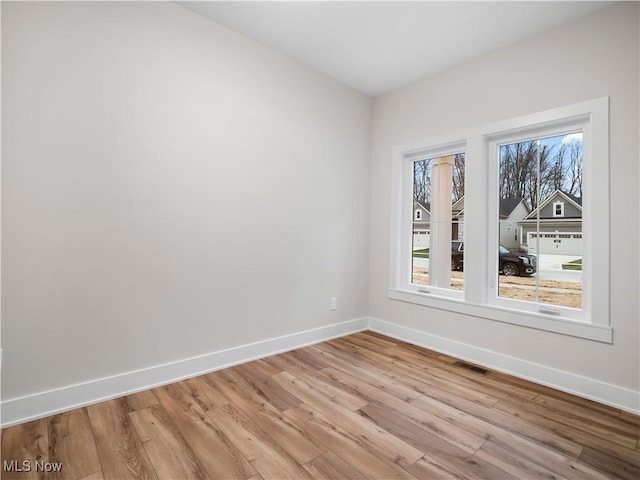 empty room featuring a wealth of natural light and light hardwood / wood-style flooring