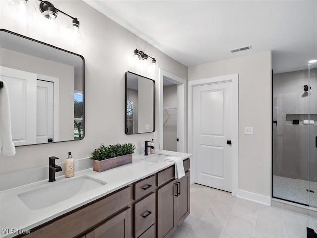 bathroom with tile patterned flooring, vanity, and walk in shower