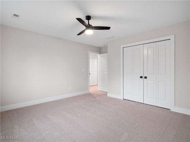 unfurnished bedroom with light carpet, a closet, and ceiling fan