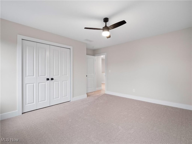 unfurnished bedroom featuring ceiling fan, a closet, and light colored carpet