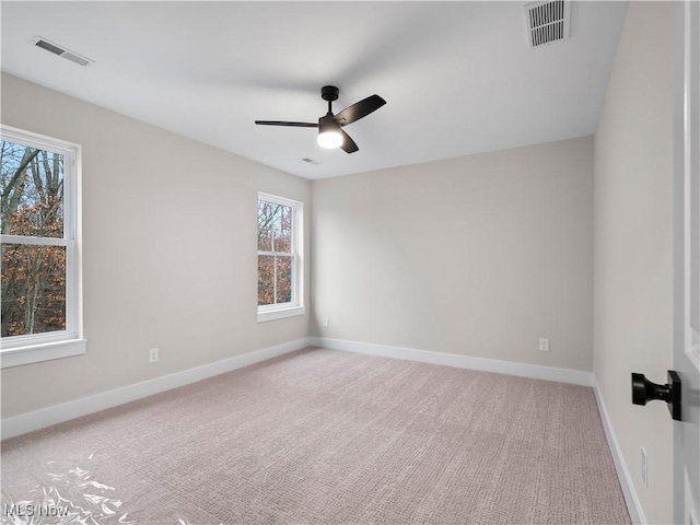 carpeted spare room featuring ceiling fan