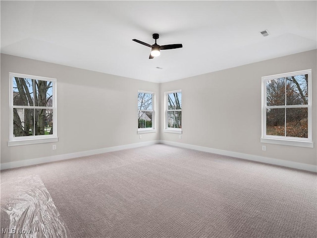 spare room featuring carpet flooring, a wealth of natural light, and ceiling fan