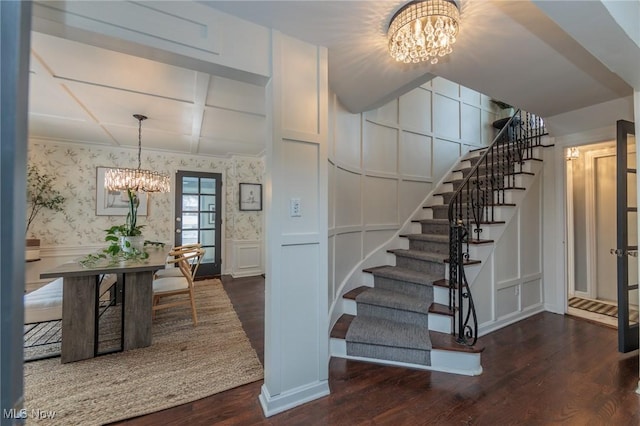 stairway featuring hardwood / wood-style flooring and a notable chandelier