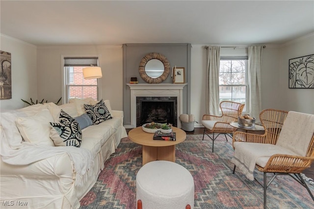 living room with plenty of natural light, crown molding, and a high end fireplace