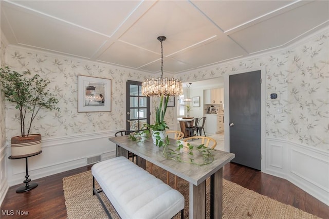 dining area with dark hardwood / wood-style flooring, an inviting chandelier, and coffered ceiling