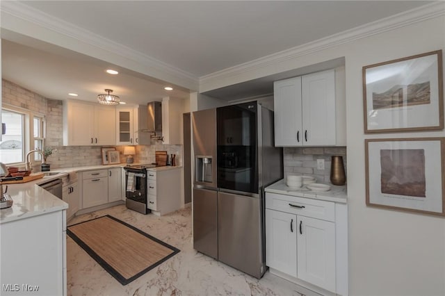 kitchen with tasteful backsplash, wall chimney exhaust hood, white cabinets, and appliances with stainless steel finishes