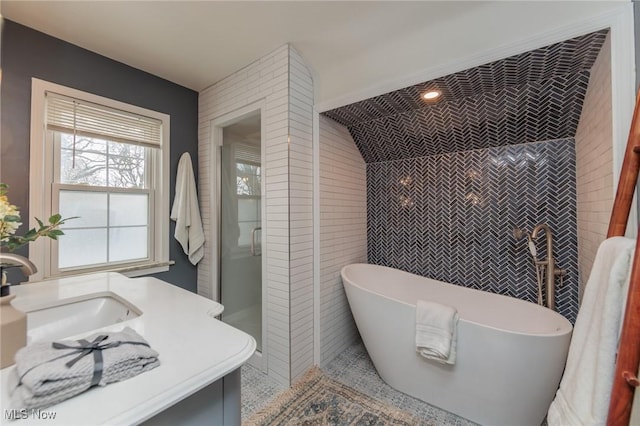 bathroom with tile patterned floors, vanity, tile walls, shower with separate bathtub, and lofted ceiling