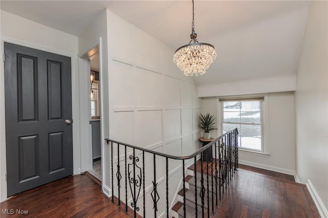 hall featuring a chandelier and dark wood-type flooring