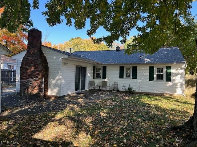 rear view of property featuring a yard