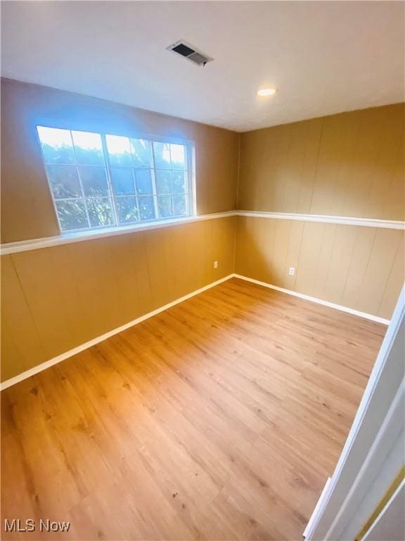 empty room with a wealth of natural light and hardwood / wood-style floors