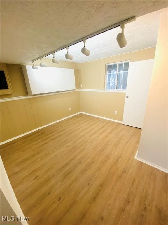 interior space with track lighting and hardwood / wood-style flooring