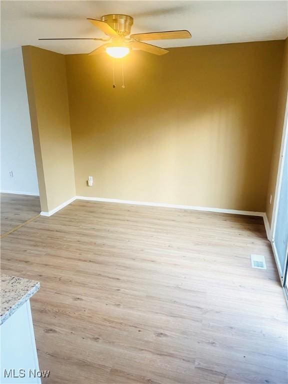 unfurnished room featuring light wood-type flooring and ceiling fan