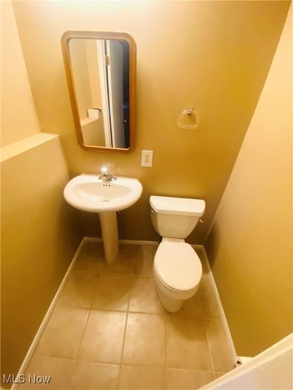 bathroom featuring sink, tile patterned flooring, and toilet