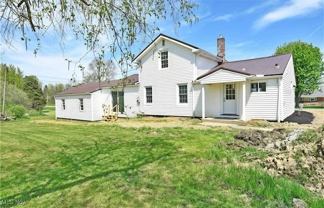 rear view of property with a lawn