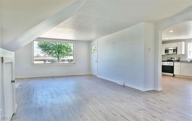 unfurnished living room with light hardwood / wood-style floors and a textured ceiling