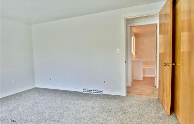 unfurnished room featuring light carpet