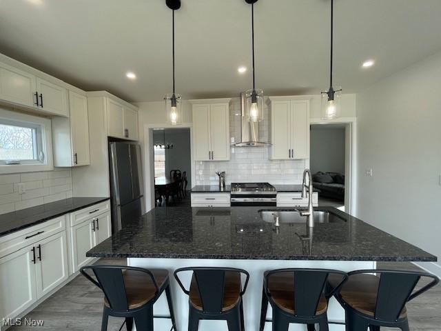 kitchen featuring sink, a center island with sink, pendant lighting, and appliances with stainless steel finishes