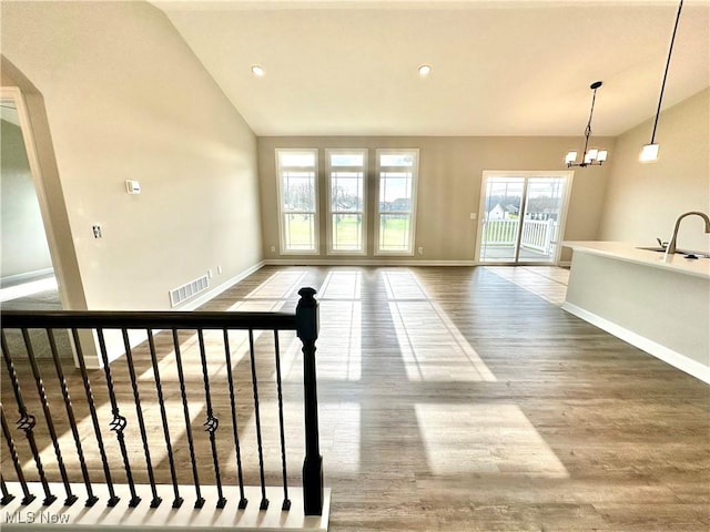 interior space featuring a chandelier, hardwood / wood-style floors, lofted ceiling, and sink