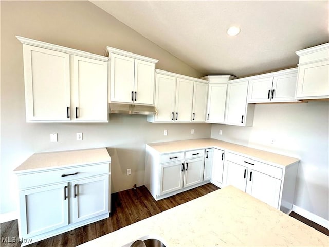 kitchen with vaulted ceiling, white cabinets, and dark hardwood / wood-style floors