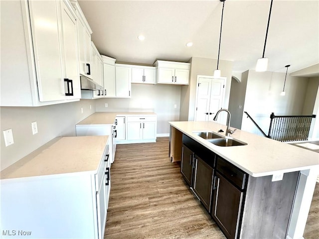 kitchen with pendant lighting, a center island with sink, white cabinetry, and sink