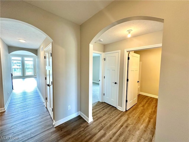 corridor featuring hardwood / wood-style floors and a textured ceiling