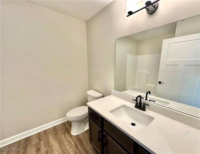 bathroom featuring vanity, hardwood / wood-style flooring, toilet, and walk in shower