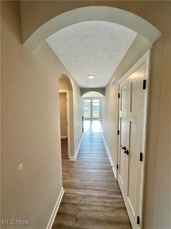 hall featuring hardwood / wood-style flooring and a textured ceiling