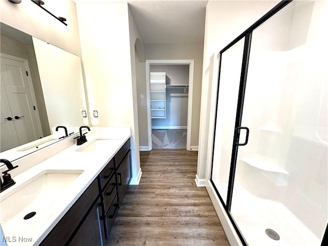 bathroom with vanity, wood-type flooring, and a shower with door