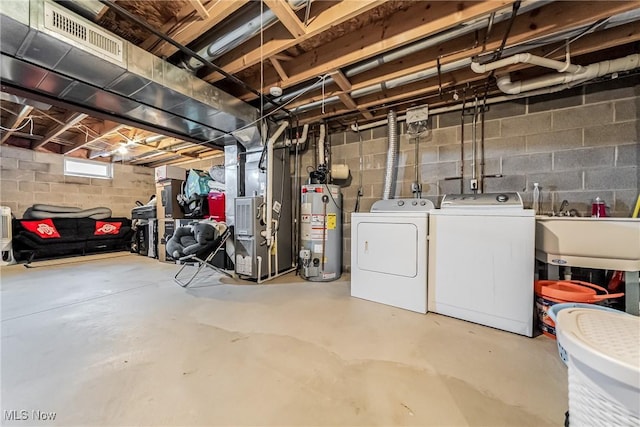 basement featuring separate washer and dryer, sink, heating unit, and gas water heater