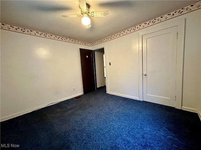 unfurnished bedroom with dark colored carpet and ceiling fan