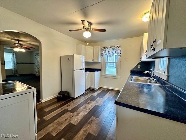 kitchen with sink, dark wood-type flooring, white refrigerator, stove, and white cabinets