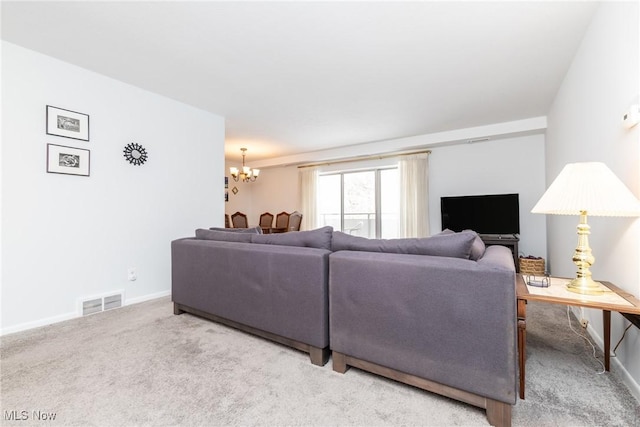 carpeted living room with a notable chandelier