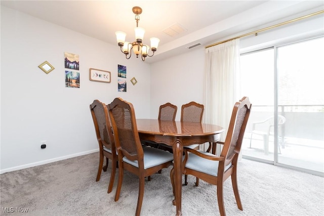 carpeted dining space with a chandelier