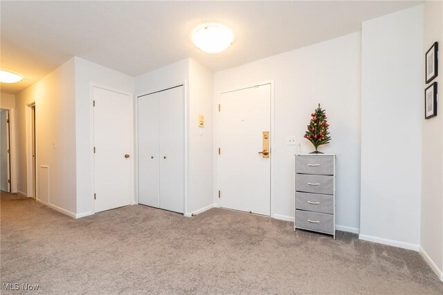 unfurnished bedroom featuring light carpet and a closet