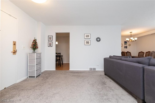 living room with carpet flooring and an inviting chandelier