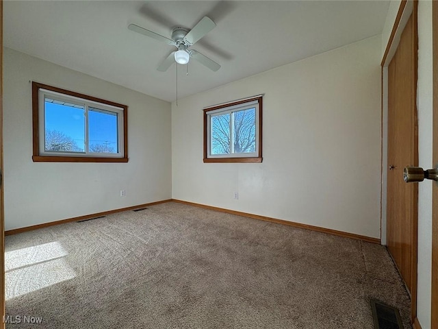 empty room featuring carpet floors, plenty of natural light, and ceiling fan