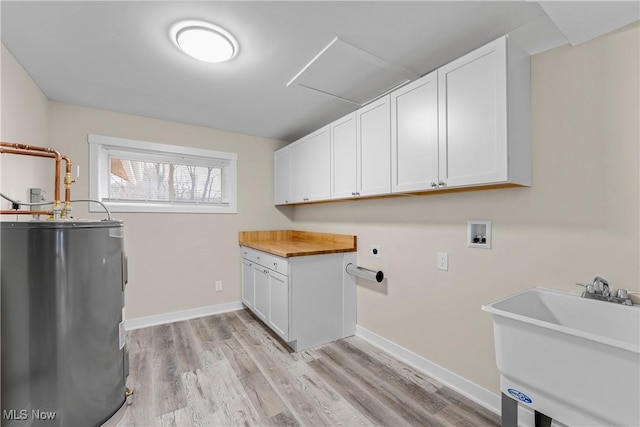 washroom with sink, hookup for a washing machine, electric dryer hookup, electric water heater, and light hardwood / wood-style flooring