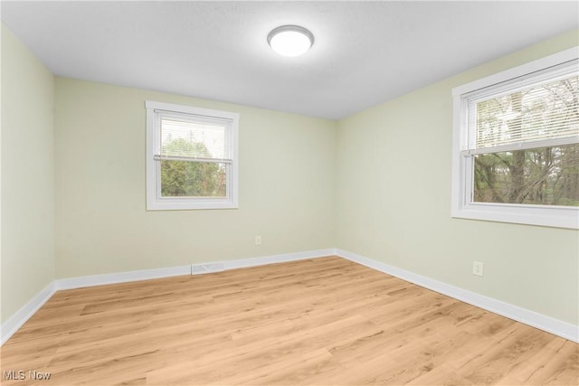 spare room featuring a wealth of natural light and light wood-type flooring