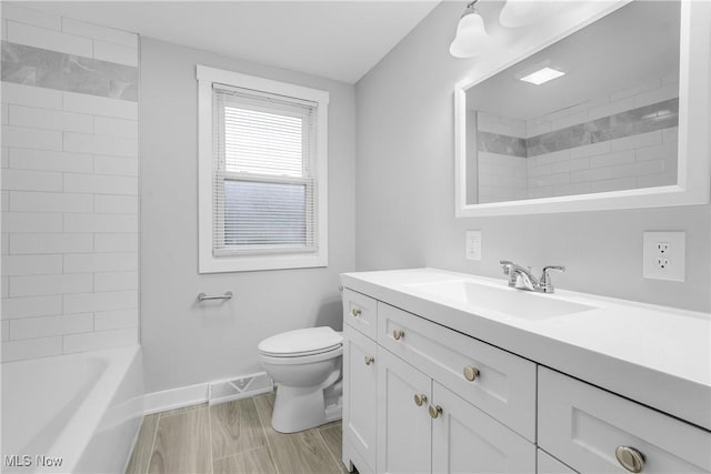 full bathroom with vanity, tiled shower / bath, and toilet