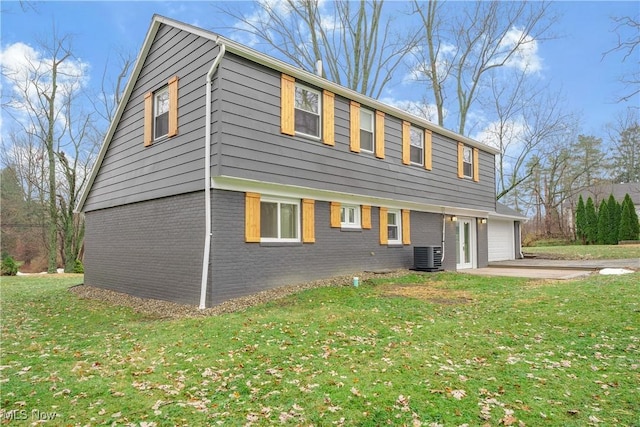 back of property with cooling unit, a yard, and a garage