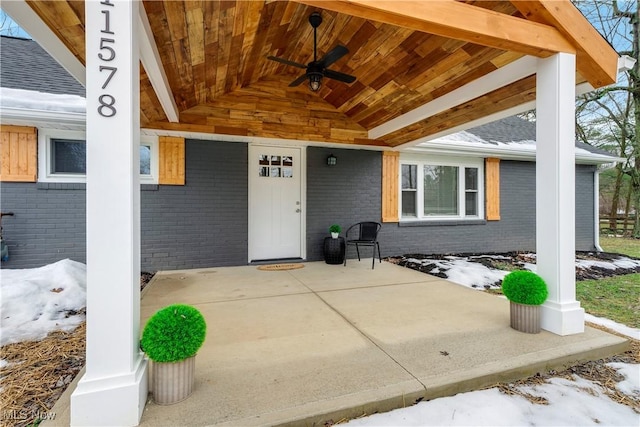 snow covered property entrance featuring a patio area and ceiling fan