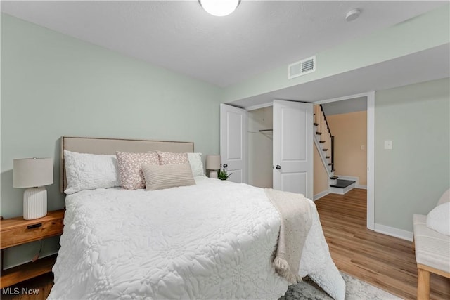 bedroom featuring wood-type flooring and a closet