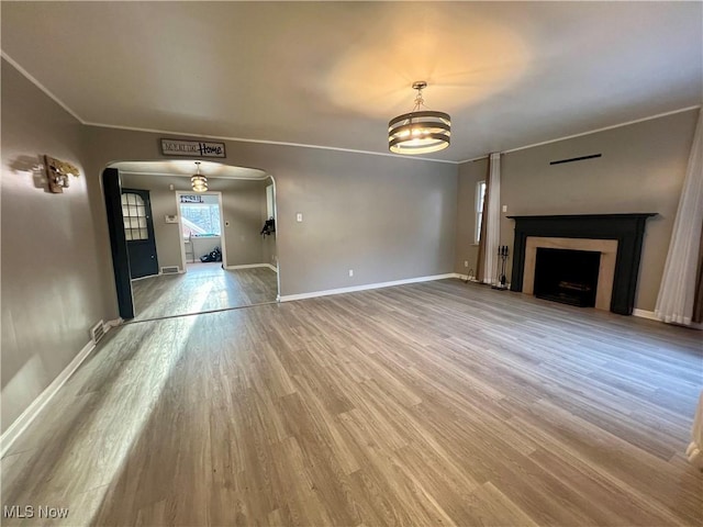 unfurnished living room with wood-type flooring and a notable chandelier