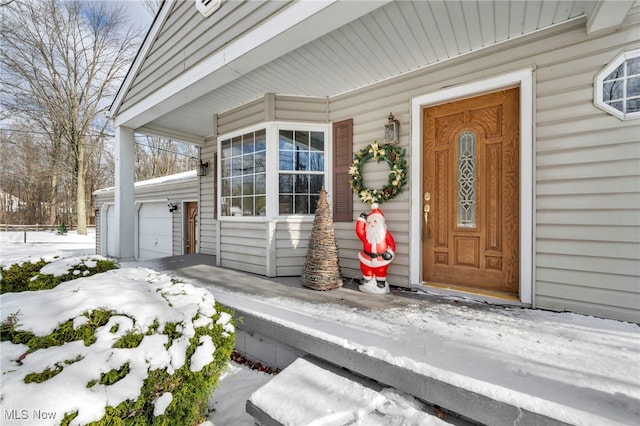 snow covered property entrance featuring a porch