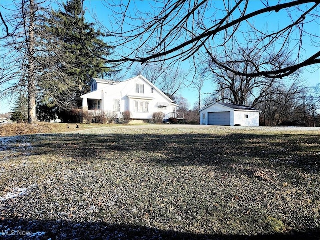 view of property exterior featuring a garage, an outdoor structure, and a lawn