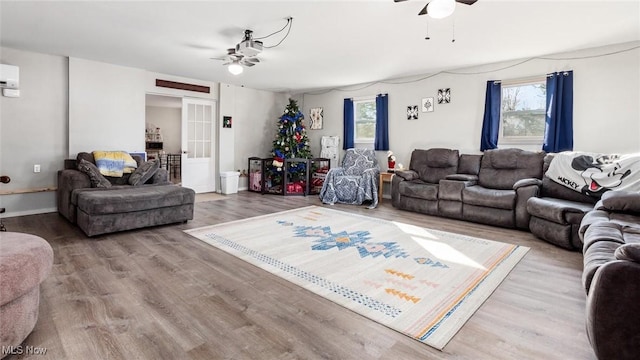 living room featuring wood-type flooring, plenty of natural light, and ceiling fan