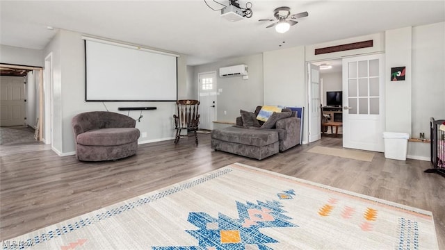 living room with ceiling fan, wood-type flooring, and an AC wall unit