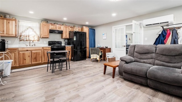 living room with sink, a wall unit AC, and light wood-type flooring