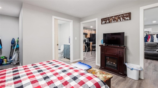 bedroom featuring ensuite bath and light hardwood / wood-style flooring